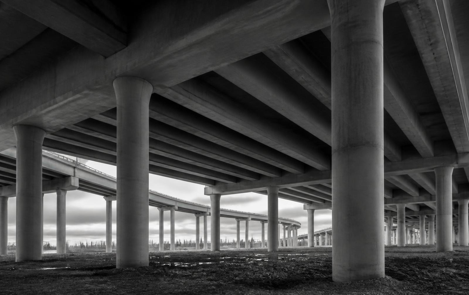 Repeating concrete columns beneath a large elevated infrastructure structure